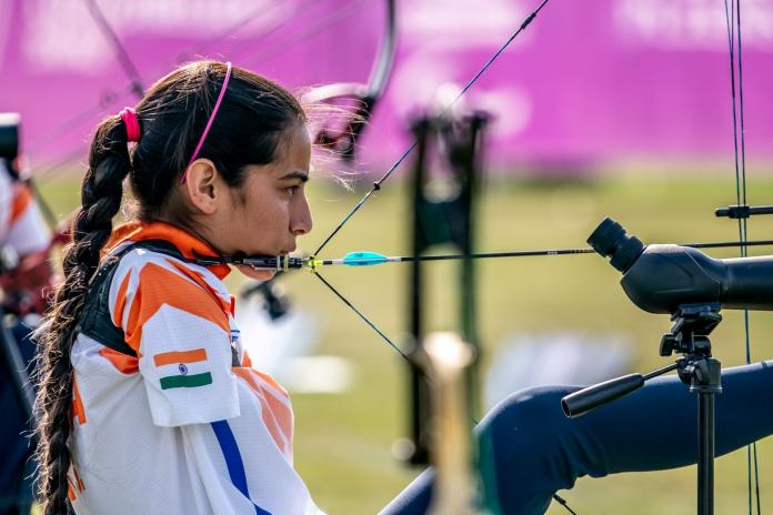 A female Para archer positions her bow with her foot 
