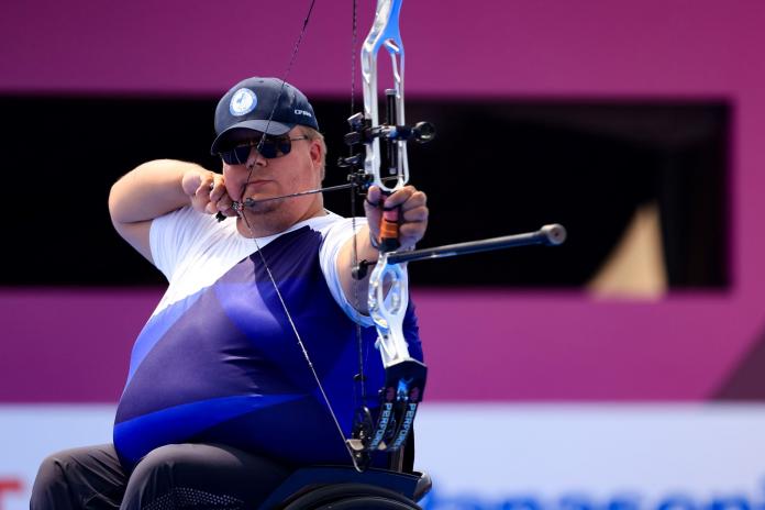A male archer positions his bow at Tokyo 2020.