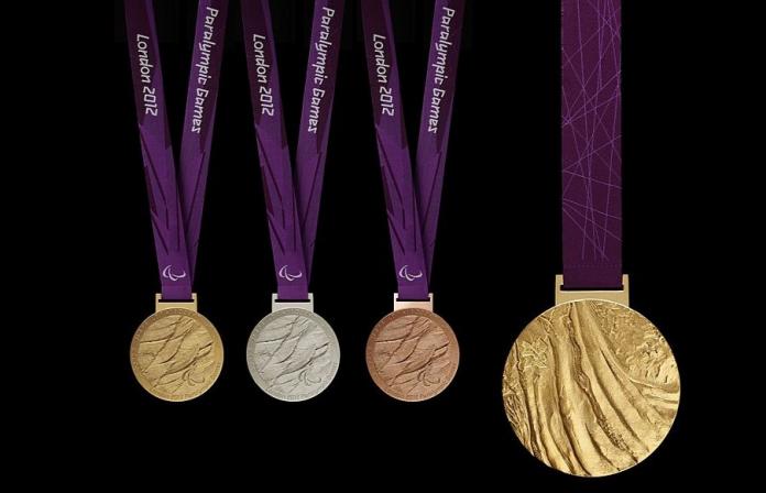 The photograph shows three medals - gold, silver, and bronze, and a gold medal
