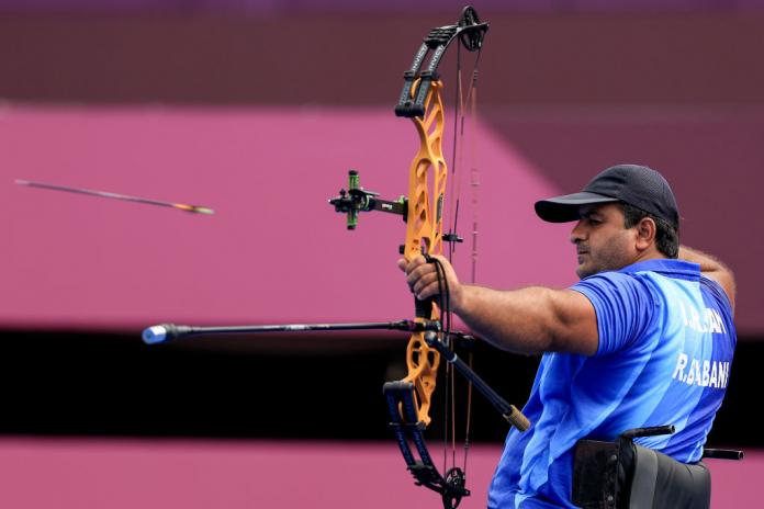 A male Para archer shoots an arrow during competition.