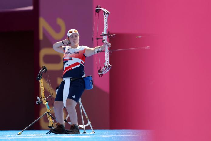 A female Para archer shoots an arrow at the Tokyo 2020 Paralympics. 