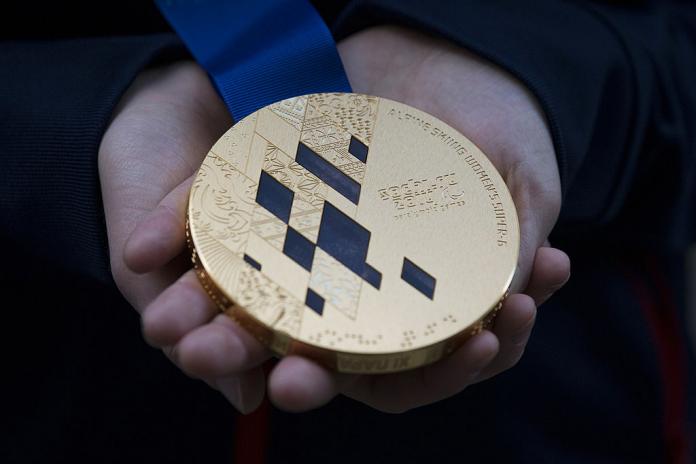 The photo shows a gold medal from Sochi 2014.