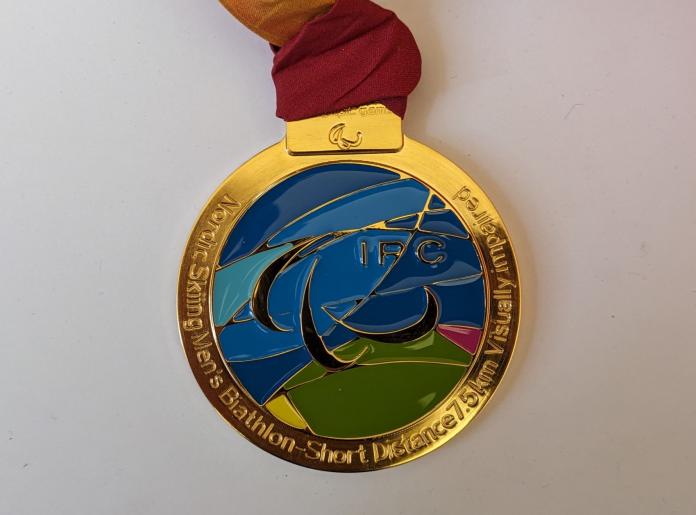 The photo shows a gold medal from the Torino 2006 Games.