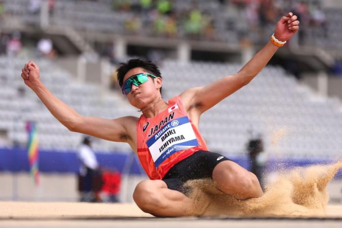 A male athlete competes in long jump.