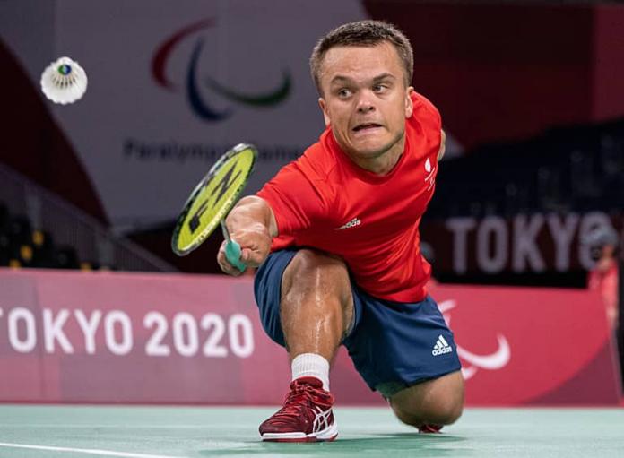 Para badminton player Jack Shephard bends down to hit the shuttlecock