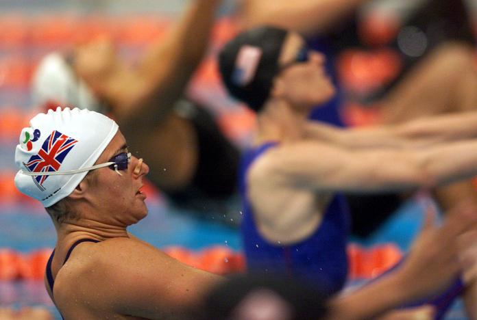 A female Para swimmer in the pool waiting for her race to start