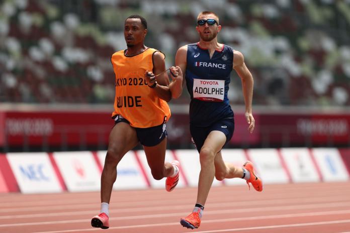 A male sprinter and his sighted guide runner competes at Tokyo 2020.
