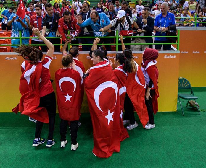 About 10 goalball players and staff high fives with the crowd after winning the Rio 2016 women's goalball competition.