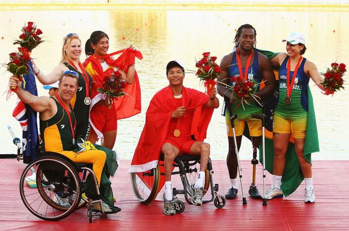 Six male and female athletes pose for a photograph on the podium at Beijing 2008