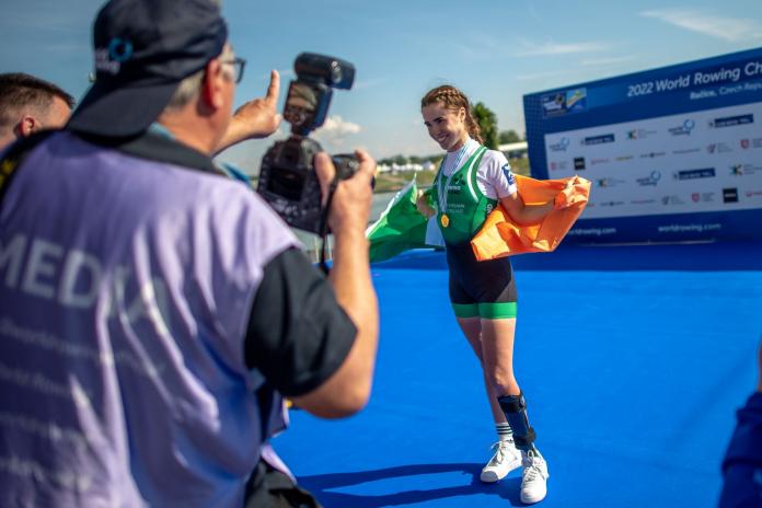 A female athlete poses for a photo with a gold medal
