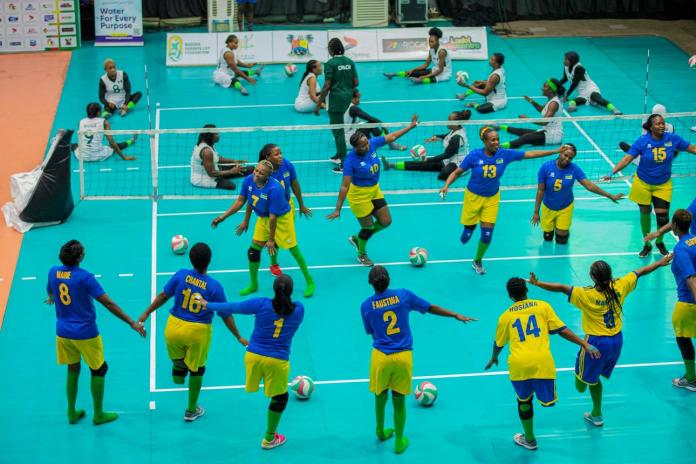 Female sitting volleyball athletes celebrating on court