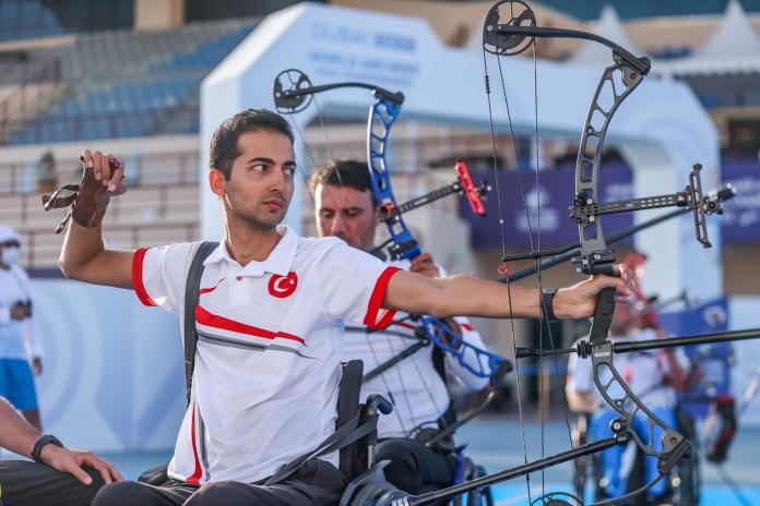 A male Para athlete shooting an arrow during competition