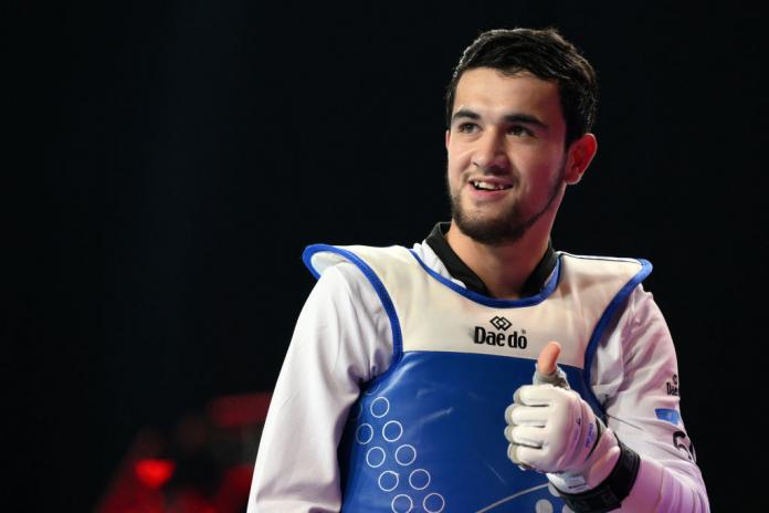 A male Para taekwondo athlete putting a thumbs up
