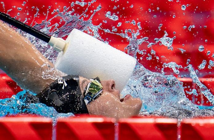 Female vision impaired swimmer is tapped in the head to make her turn
