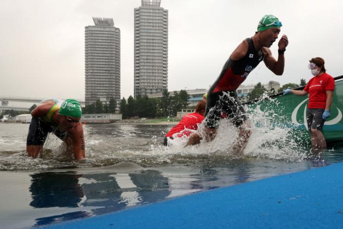 Male triathletes exit the water after the swimming segment