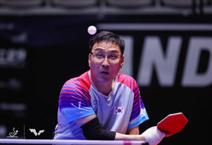 A male Para table tennis player prepares to return the ball.