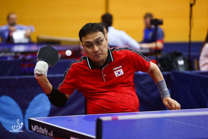 A male Para table tennis player prepares to return the ball.
