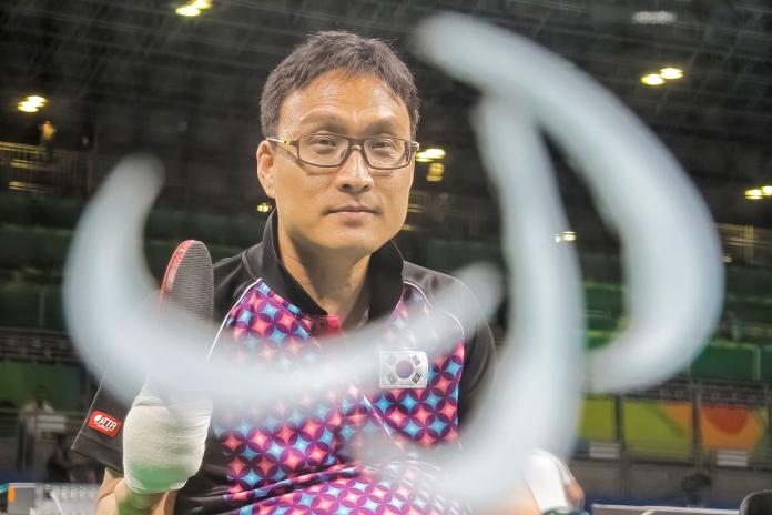 A male Para table tennis player prepares to return the ball.
