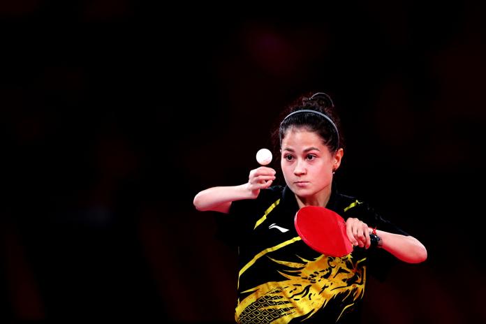 A female Para table tennis player throws a ball to serve