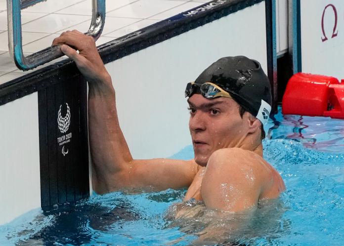 A male Para swimmer is in the pool