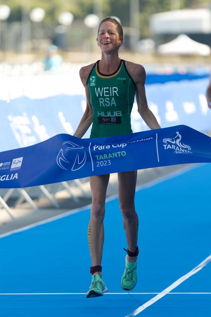 A female triathlete crosses the finishline