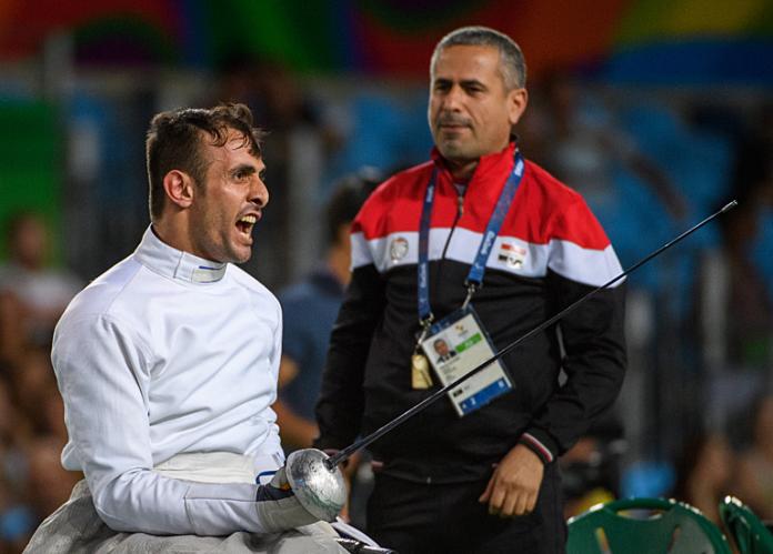 A male wheelchair fencing athlete reacts