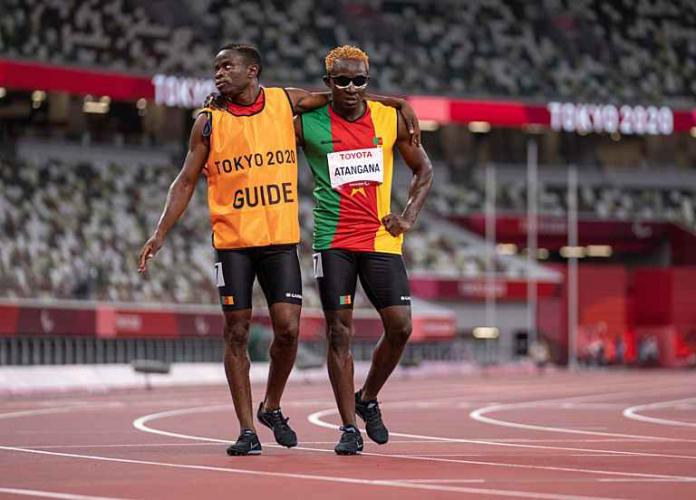 Guillaume Junior Atangana and his guide with their arms around eachother