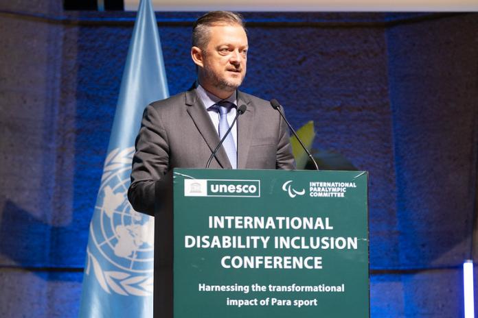 O presidente do IPC, Andrew Parsons, sorrindo em frente a um microfone