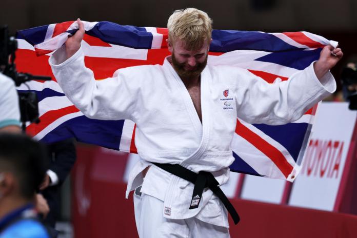 Christopher Skelley of Team Great Britain reacts after a victory. He is holding the British flag