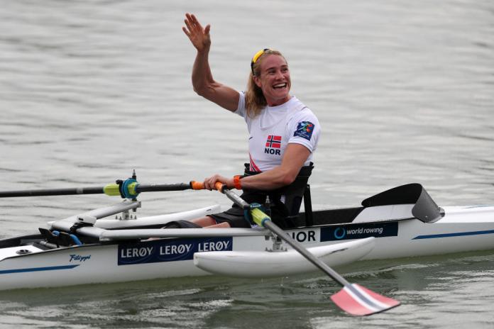 Birgit Skarstein waves and smiles while in her rowing boat