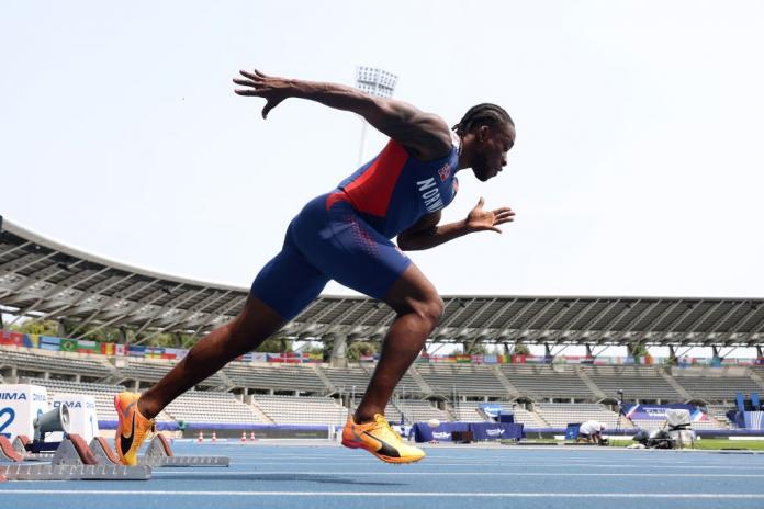 A man in a Team Norway uniform launches himself off the starting block at an athletics track