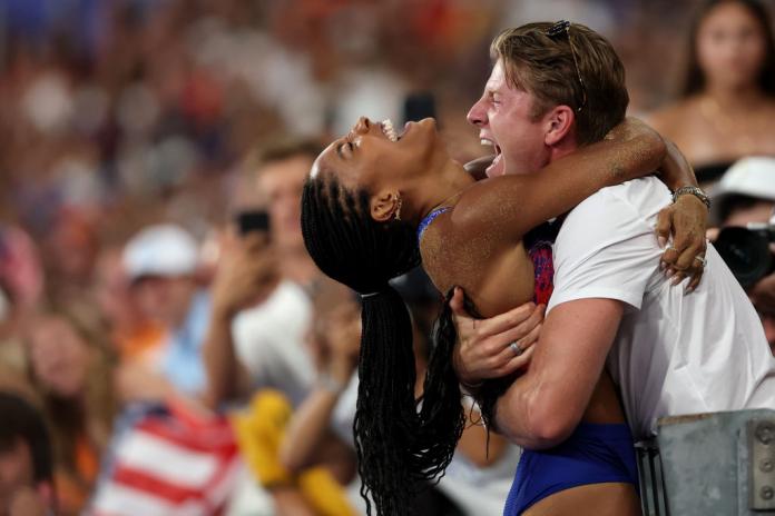 Tara and Hunter Woodhall hugging and celebrating at the side of the track