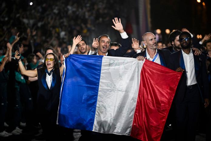 A group of French Para athletes parading with the national flag 