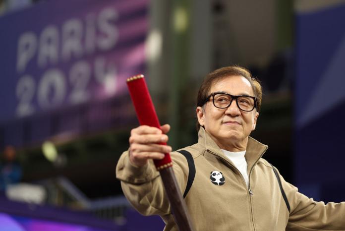 Hollywood star Jackie Chan, wearing a brown jacket, addresses the crowd at Para taekwondo