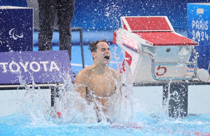 Para swimmer Ugo Didier splashes the water in celebration