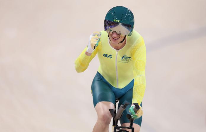Korey Boddington raises an arm in celebration at the end of a track cycling race