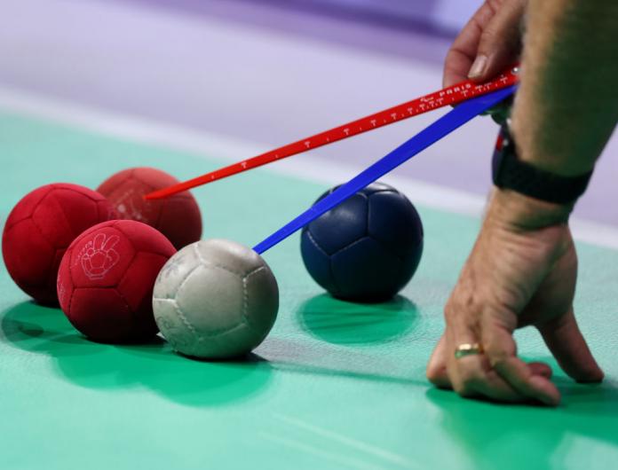 A closeup of a hand measuring the distance between the balls
