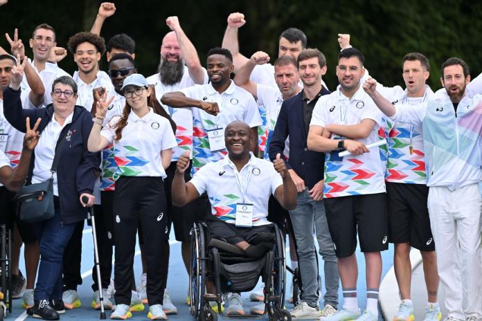 A group photo of the Refugee Paralympic Team and officials. Nyasha Mharakurwa, the chef de mission of the team, is posing in the centre