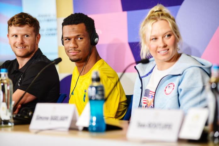 Two men and a woman at a press conference table