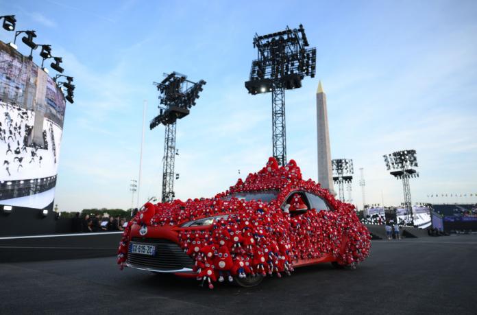 Um carro vermelho decorado com mascotes em miniatura