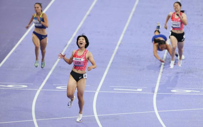Xiaoyan Wen reacts after crossing the finishline