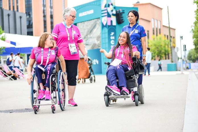 Two female athletes and their mothers chat in the Paralympic Village