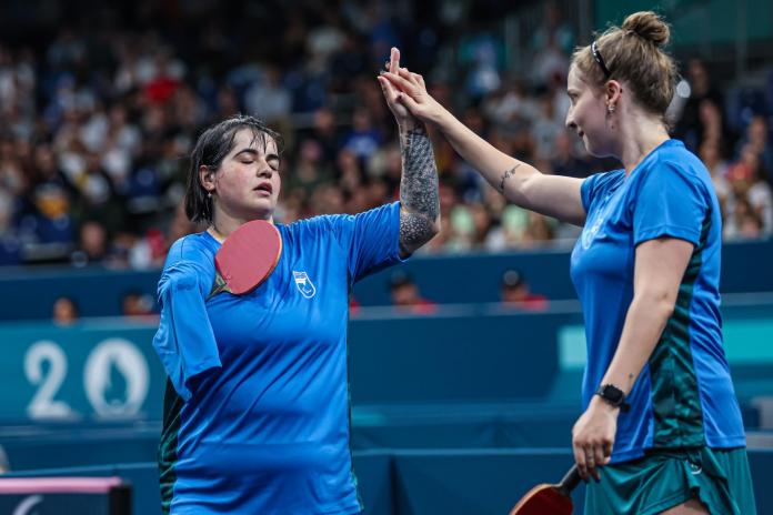 Para table tennis player Bruna Alexandre high-fives her teammate