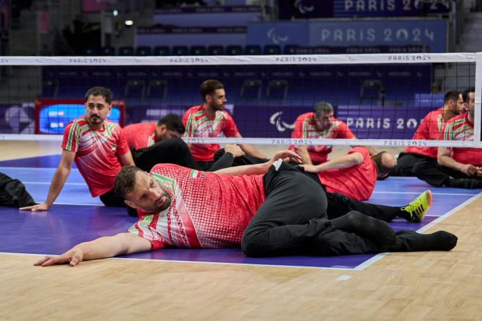 Morteza Mehrzadselakjani stretching on court as a pre-match warm-up