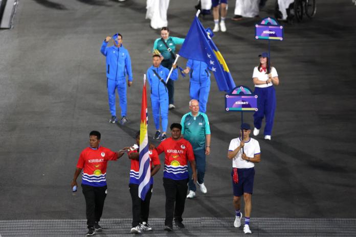 Para athlete Ongiou Timeon carries the Kiribati flag