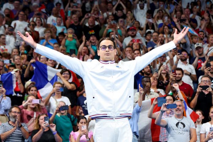 Ugo Didier holds his arms out wide as the crowd cheers 