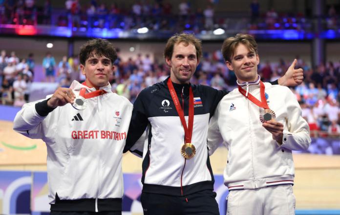 Three men pose with medals
