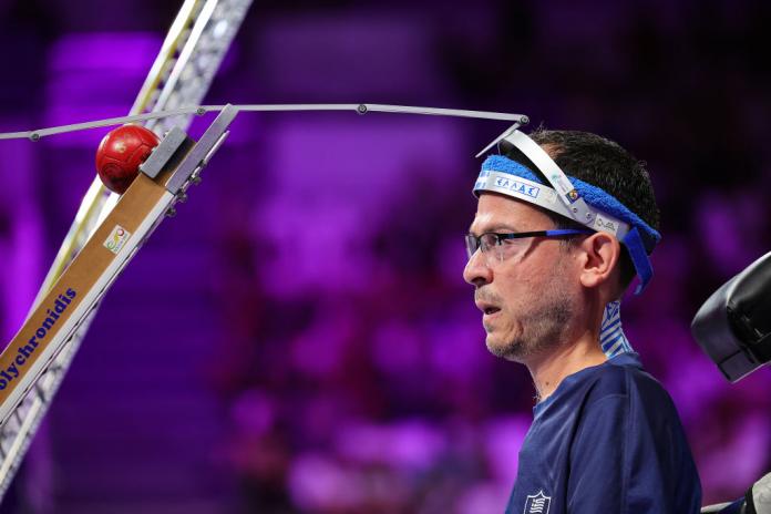 Boccia player Greg Polychronidis lines up a shot with his head