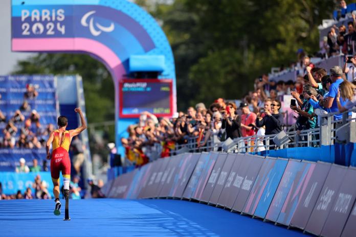 Para triathlete Daniel Molina salutes the crowd as he crosses the finish line
