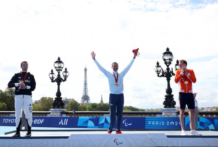 Para triathlete Daniel Molina raises his arms in celebration on the podium